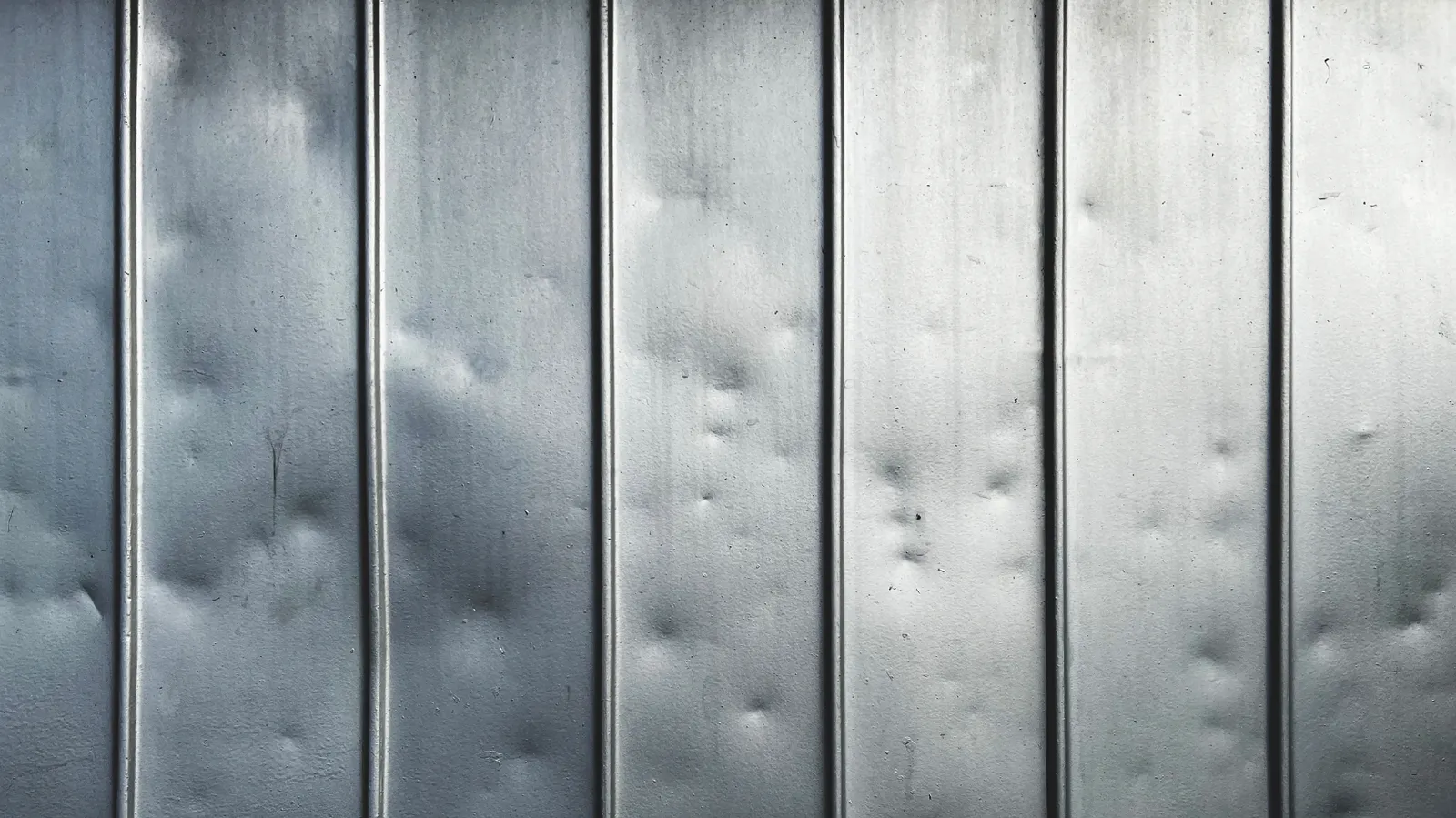 Ribbed sheet metal panels with small dents scattered across them